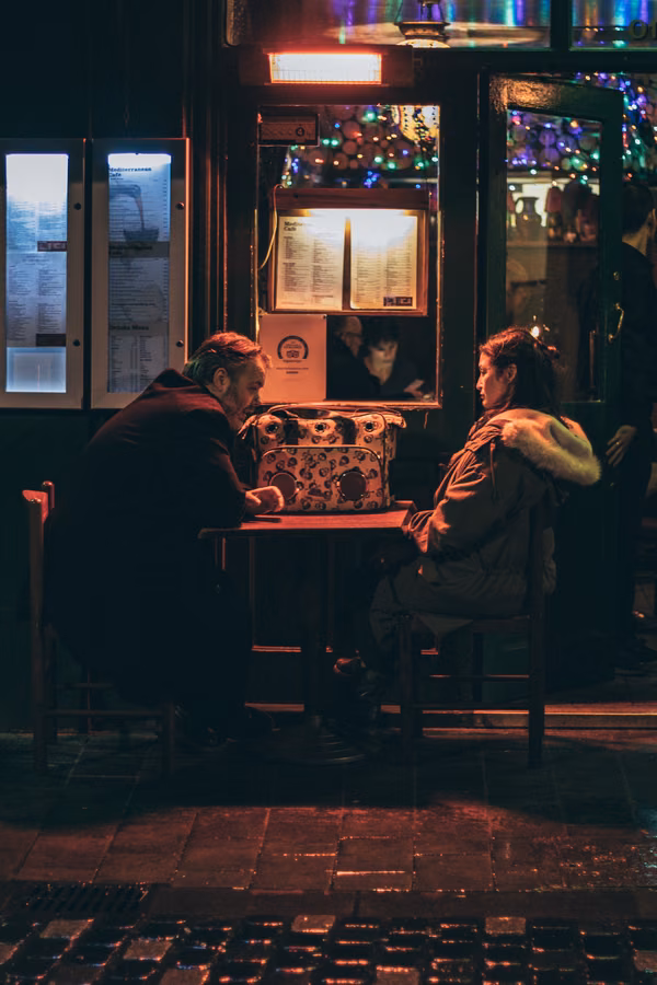 Couple talking at a table in a dimly lit restaurant