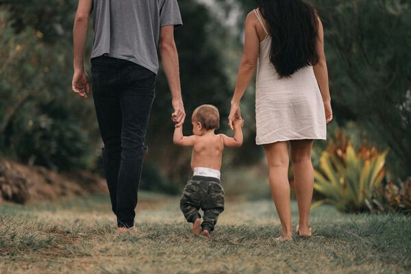 Couple holding hands of a small child