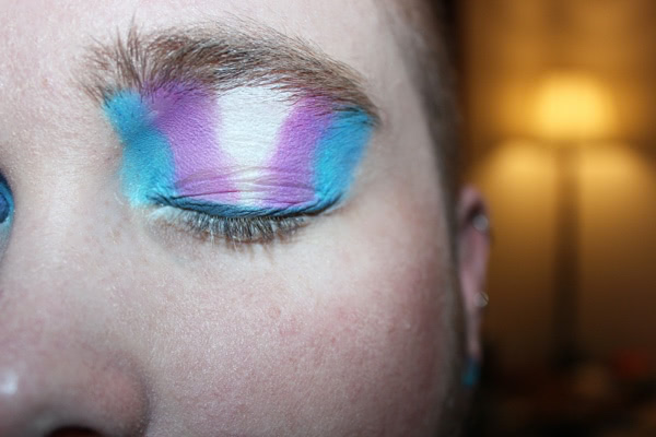 A closed eye with multi-colored eye shadow