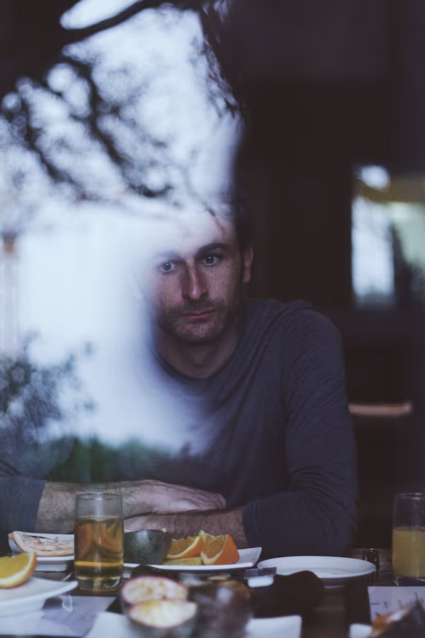 Man gazing out a window, looking forlorn