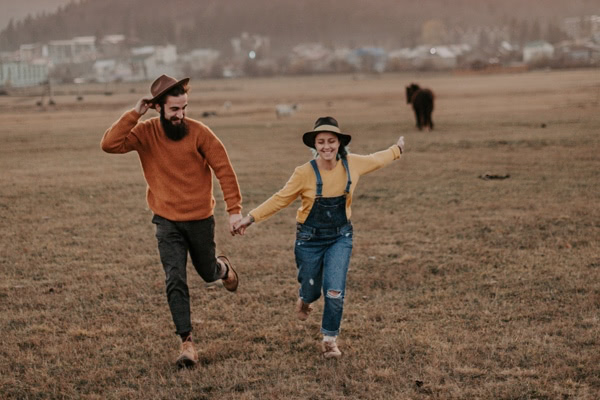 Happy couple running in a field