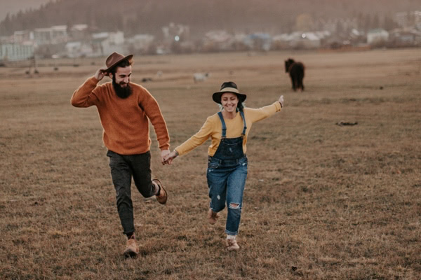 Happy couple running in a field